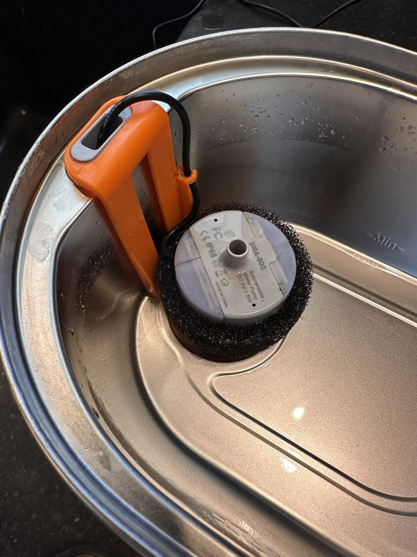 Open PETLIBRO fountain reservoir with pump, orange housing, and foam pre-filter visible