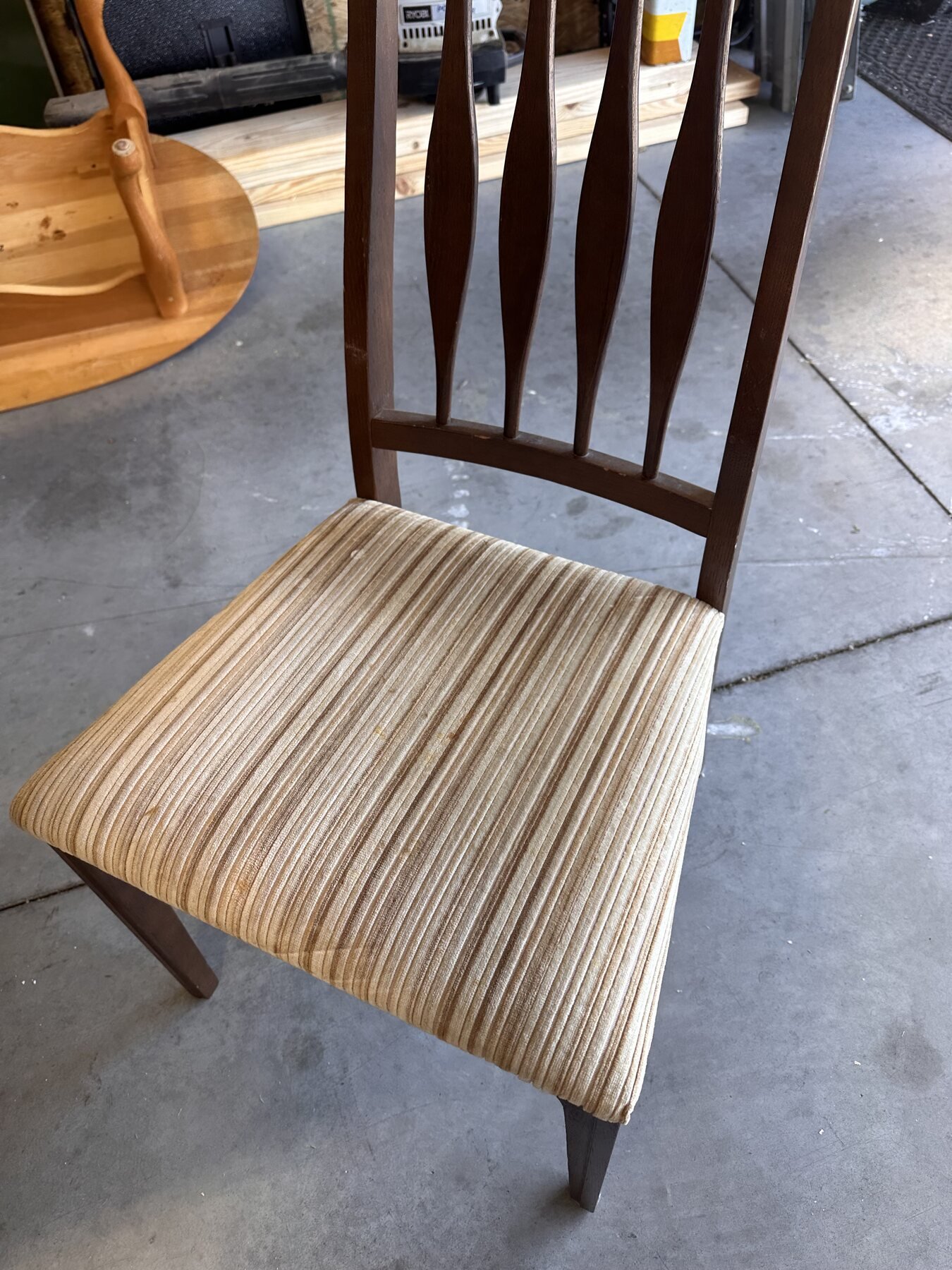 Full view of the first wooden chair with striped upholstered seat