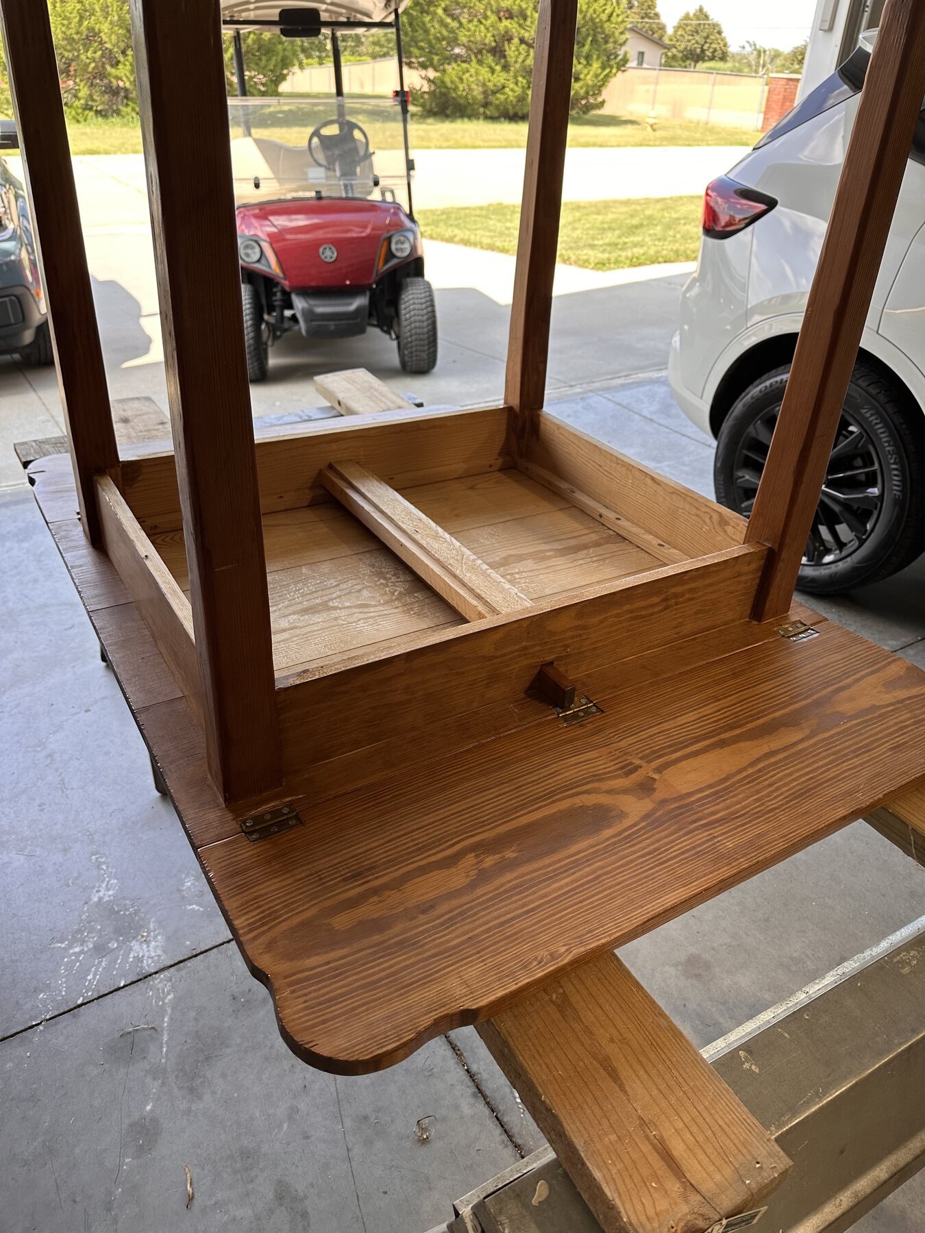 Drop-leaf table resting upside down on padded boards for its first workbench session