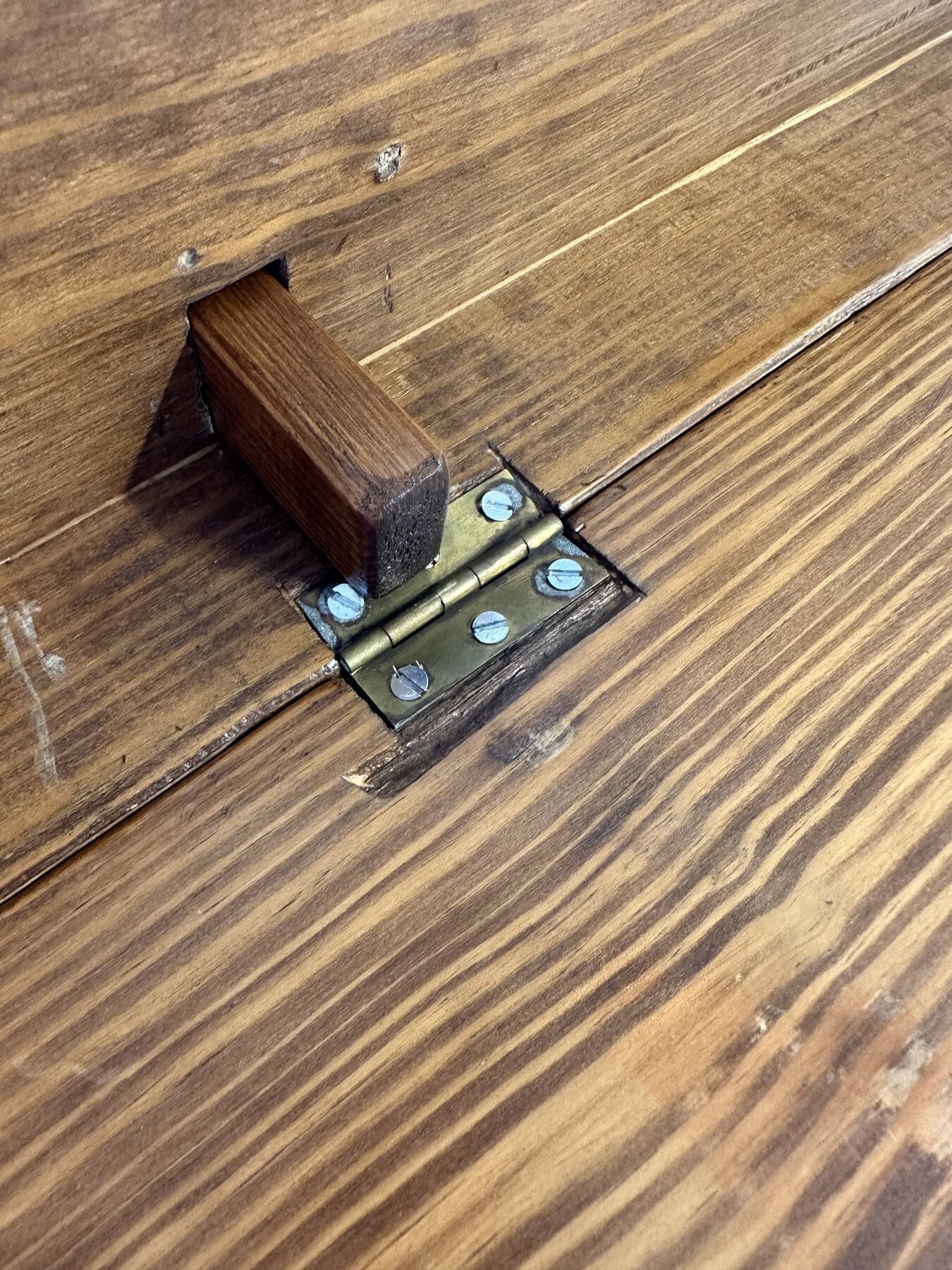 Sliding wooden support brace passing through an apron opening next to a leaf hinge