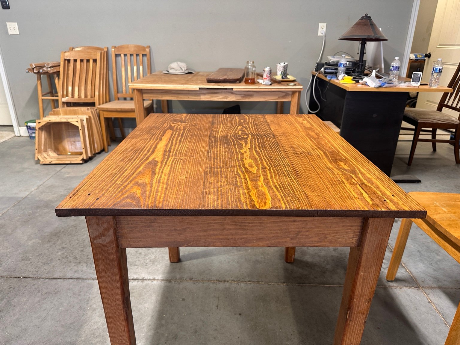 Front workshop view of the drop-leaf table after its second polyurethane coat, with other furniture projects behind it