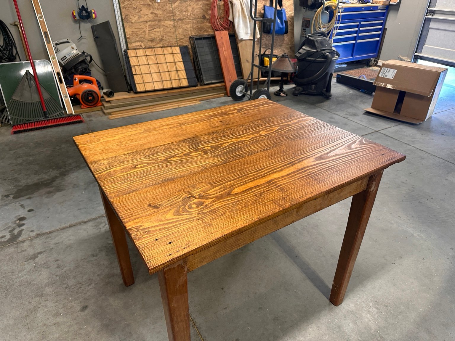 Wide left-front view of the table in the working garage after polyurethane layer three