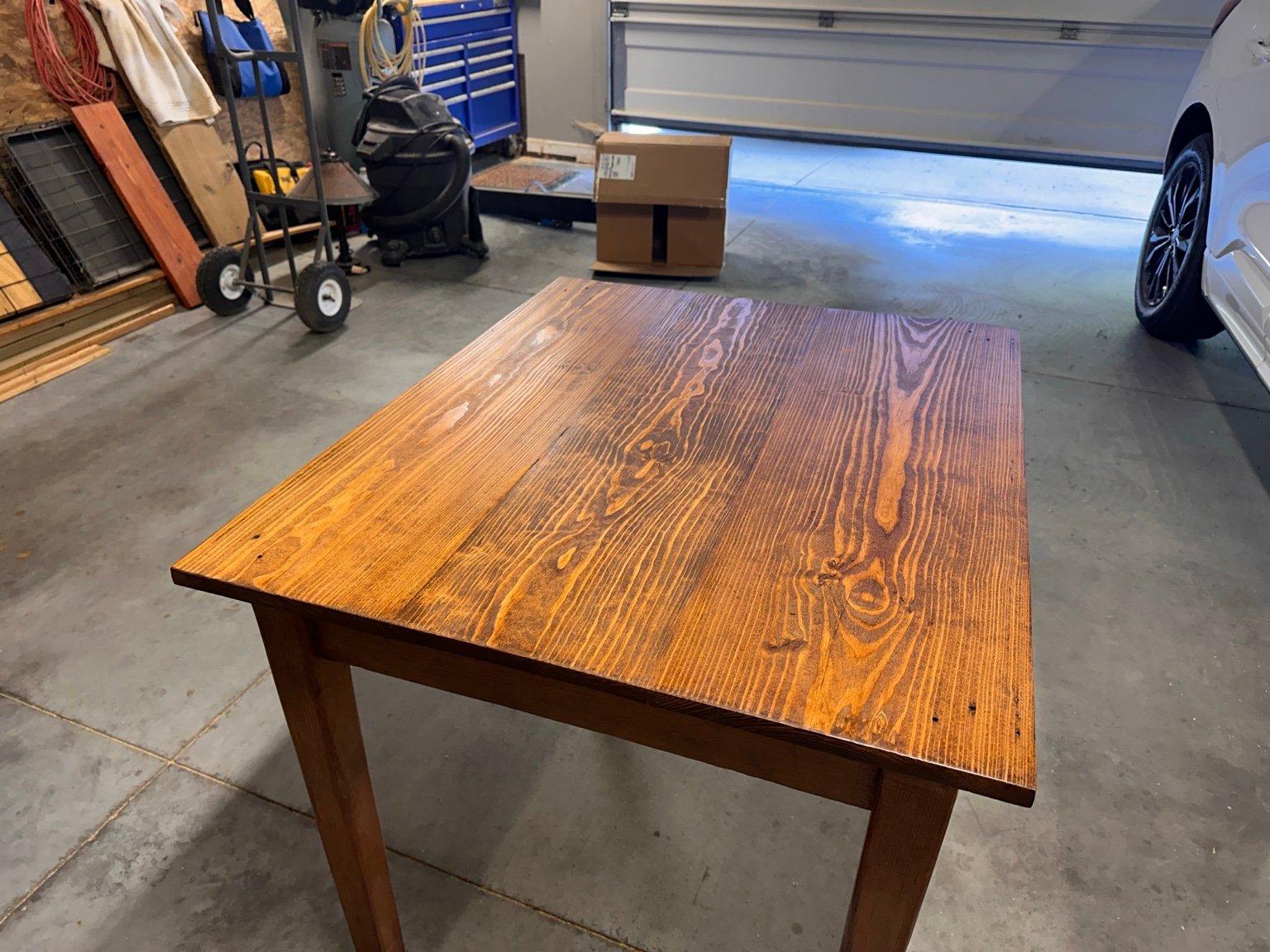 Rear diagonal view of the tabletop near the partly open garage door after polyurethane layer three