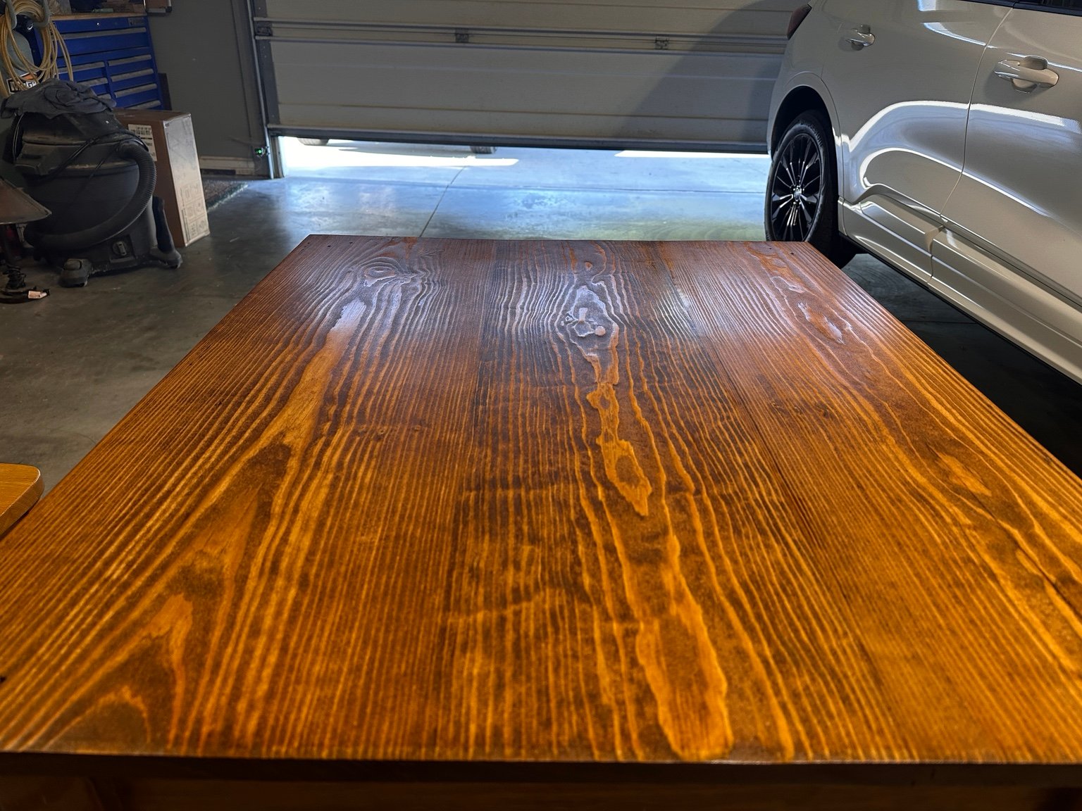 Low front view across the tabletop toward the partly open garage door after coat four