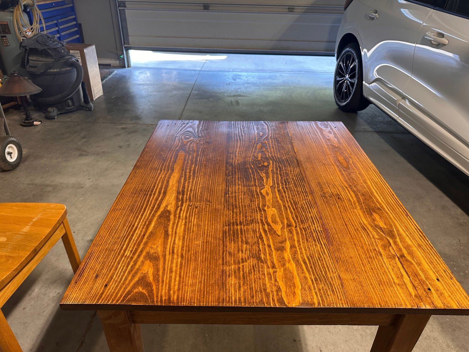 Wide centered view of the table after the fourth coat with the garage door behind it