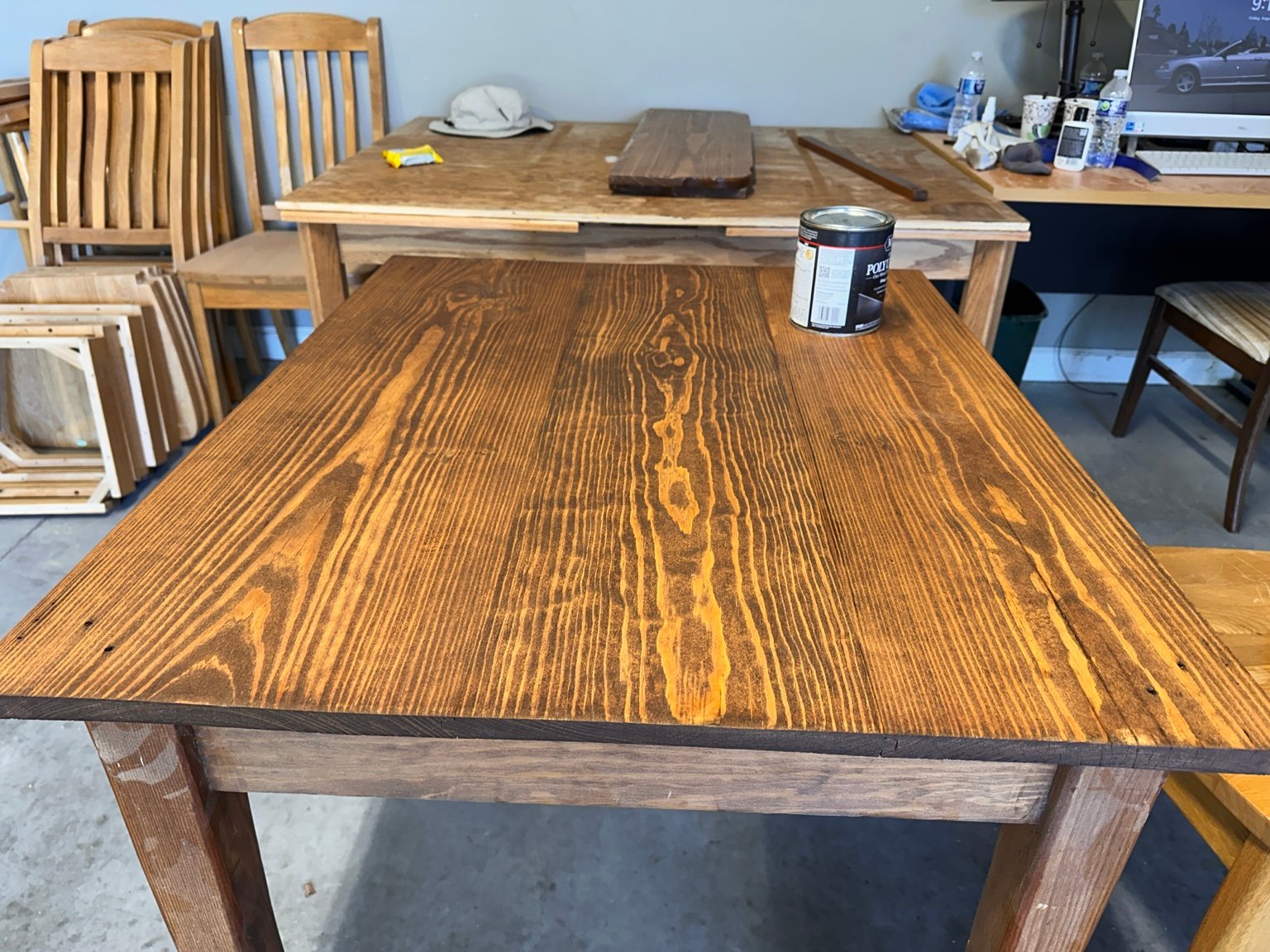Fully stained center tabletop with dark grain and warm brown color in the garage workshop