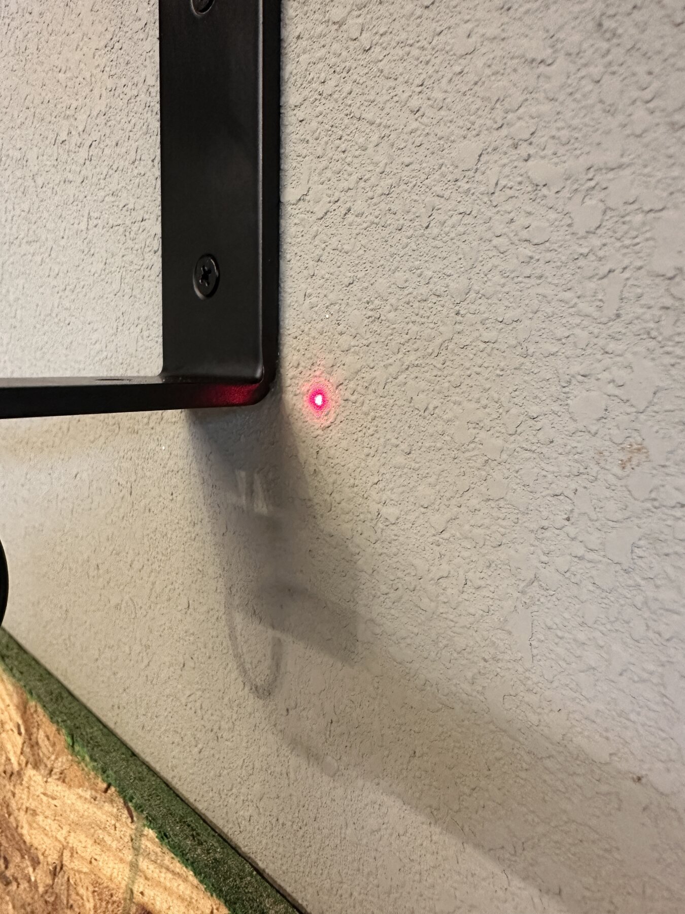 Close-up of laser level dot beside shelf bracket