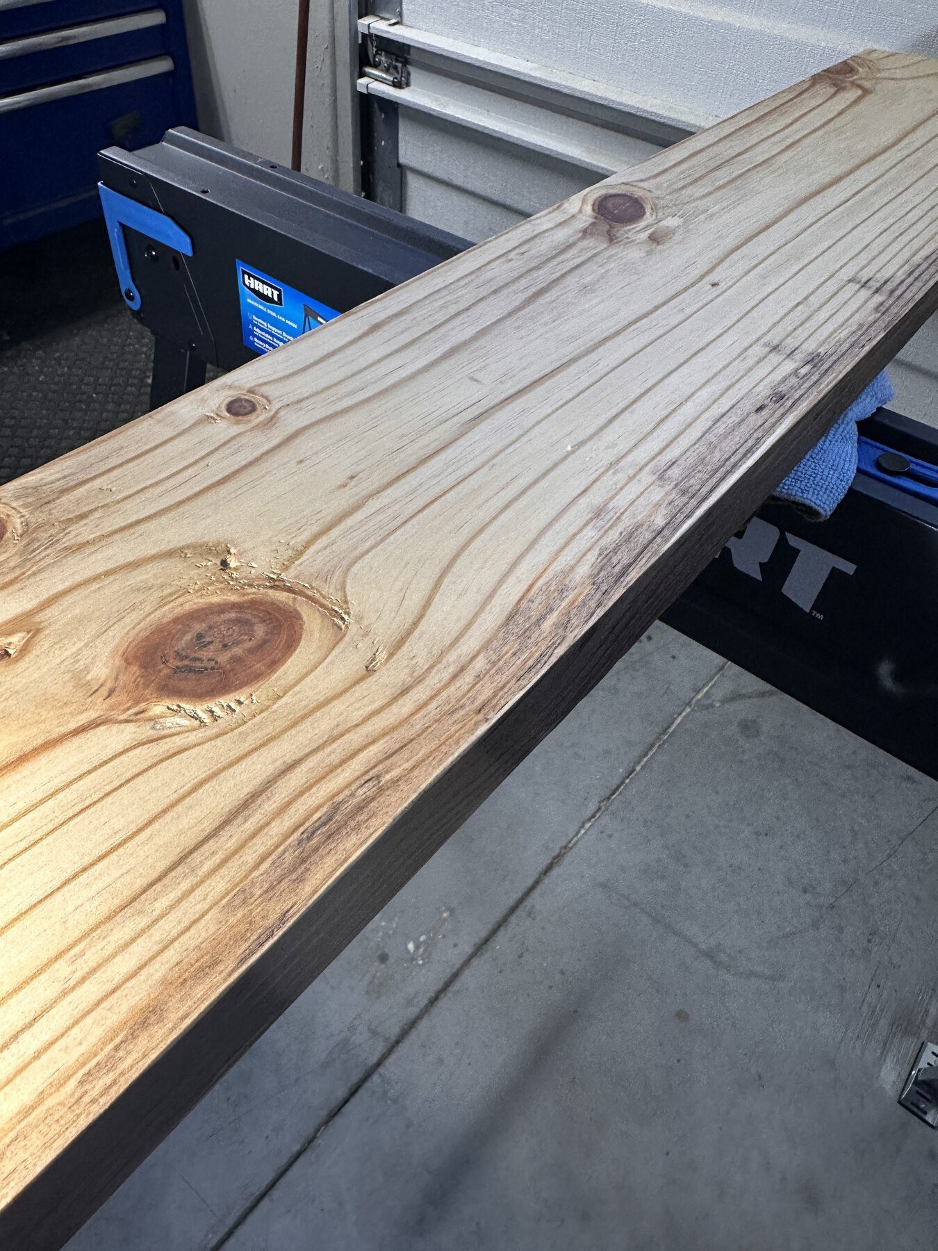Angled view of stained Board Two showing several knots and darkened grain
