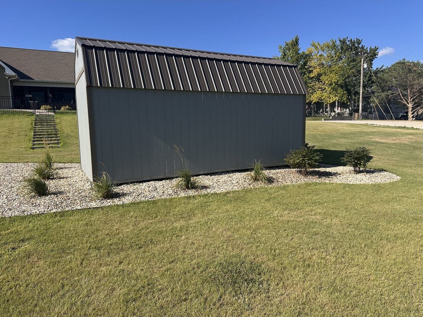 Long side of the shed with grasses and burning bushes