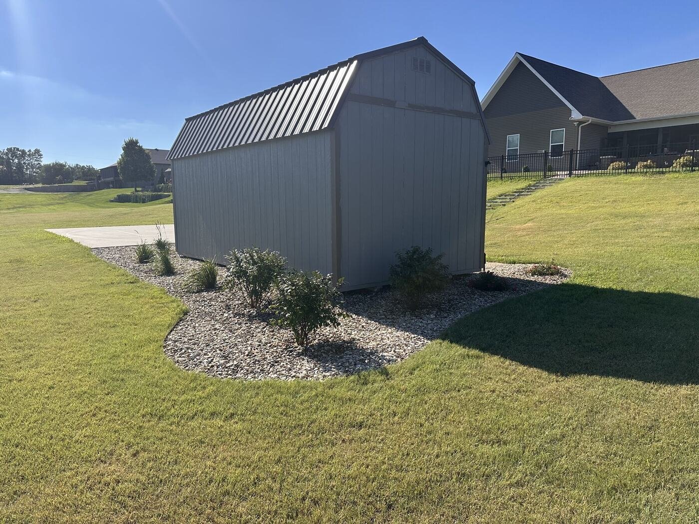 Corner view showing grasses, shrubs, and roses around the shed